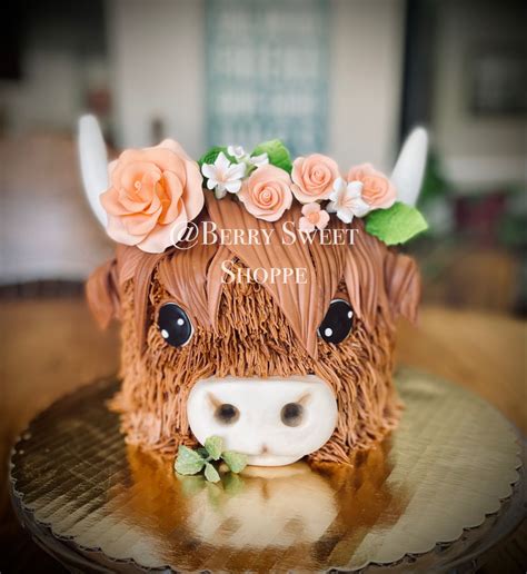 a cake shaped like a cow with flowers on its head