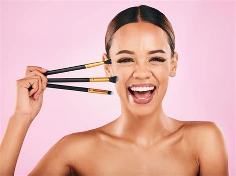 Premium Photo | Happy woman portrait and makeup brushes for beauty cosmetics against a pink ...