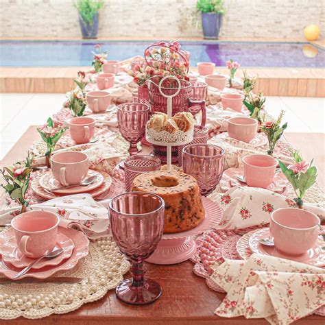 the table is set with pink dishes and cups