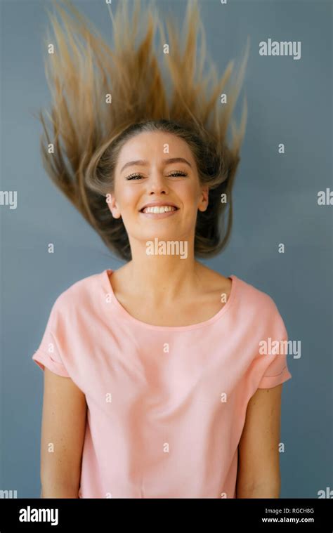 Portrait of smiling young woman tossing her hair Stock Photo - Alamy