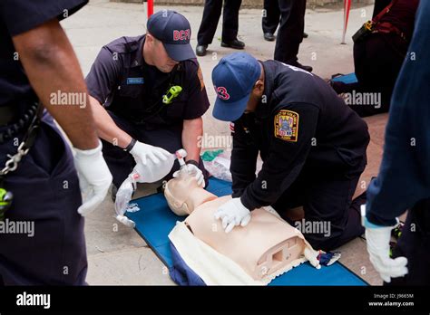 Fire and EMS technicians (EMT, Paramedic) performing CPR on CPR manikin (CPR training ...