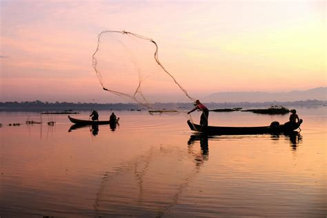 Fisherman throwing Net into Body of Water · Free Stock Photo