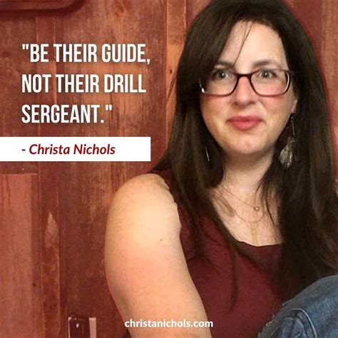 a woman with glasses sitting in front of a wooden wall and a quote on it