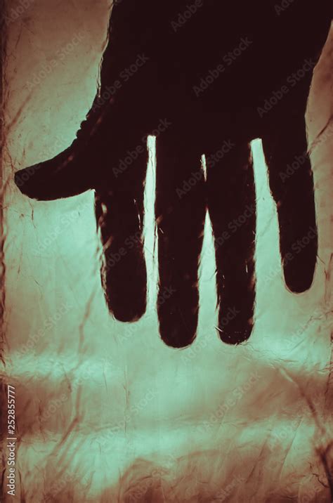 Creepy silhouette of hand on red blurred background Stock Photo | Adobe Stock