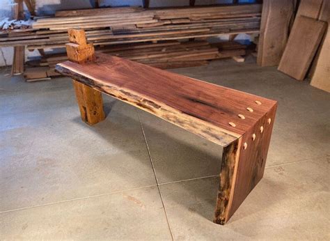 a wooden bench sitting on top of a cement floor next to wood planks in a building