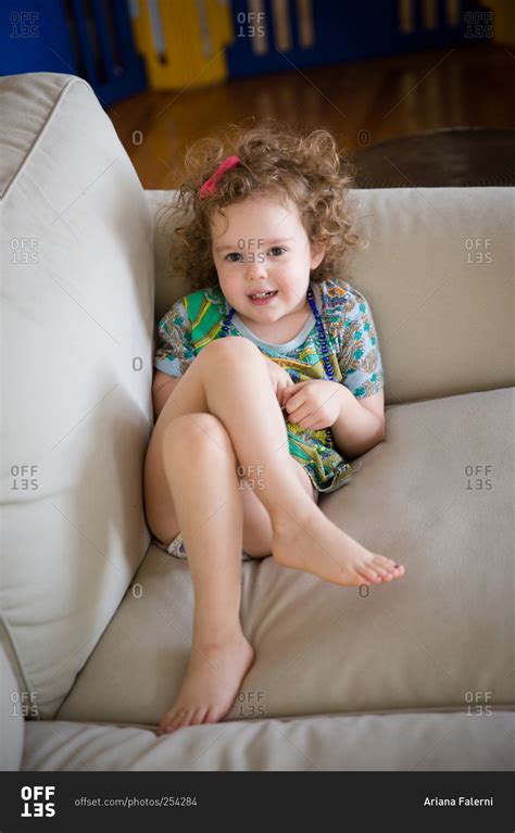 Little girl lying on a couch stock photo - OFFSET