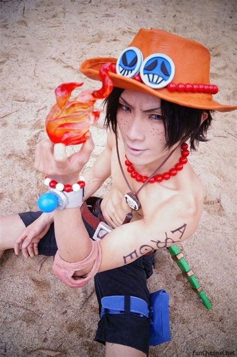 a man wearing a hat and bracelets on the beach with his arm wrapped around an orange object