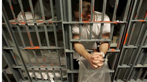 An inmate leans out the bars of his cell in a one -prisoner-per-cell block in downtown Los ...