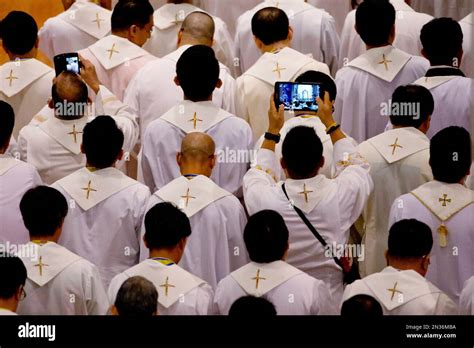 FILE - In this Friday, Jan. 16, 2015, file photo, priests take photos as Pope Francis arrives to ...