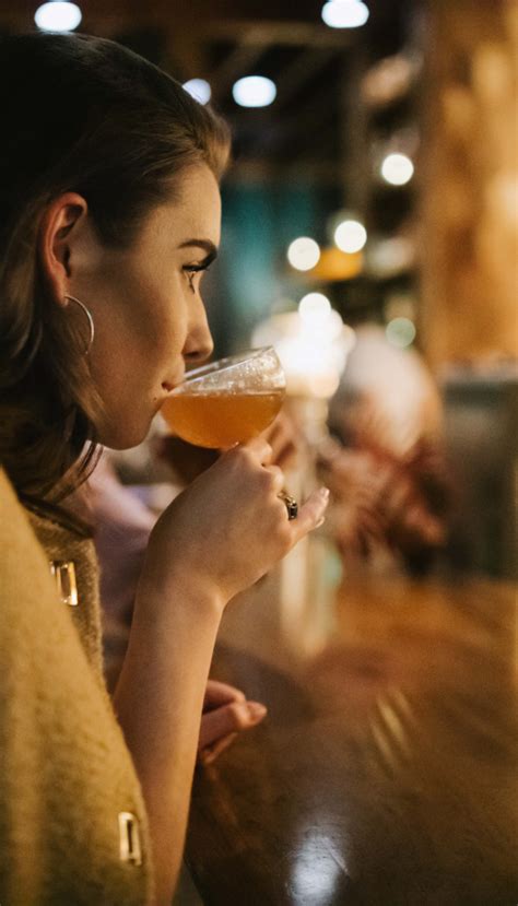 woman sips from cocktail