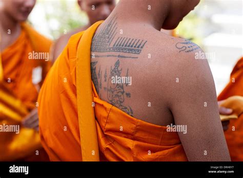 Exposed shoulder of a monk showing his tattoos Wat Pho Bangkok Thailand ...