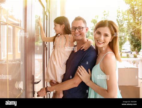 Happy family opening door of their new house Stock Photo - Alamy