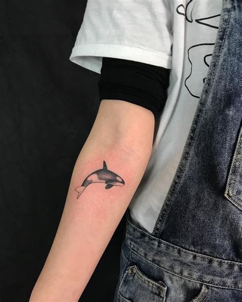 a small dolphin tattoo on the arm