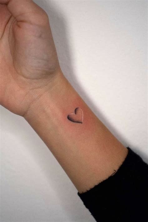 a small heart tattoo on the wrist