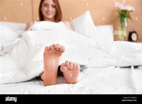 Feet of beautiful young woman lying in bed Stock Photo - Alamy