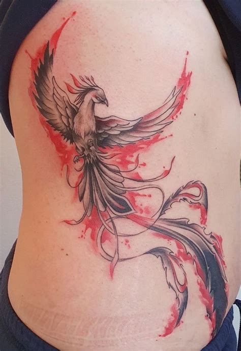 a woman's stomach with an artistic tattoo design on the side, featuring a bird