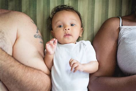 "Biracial Baby Lying In Bed Between Her Black Mother And White Father" by Stocksy Contributor ...