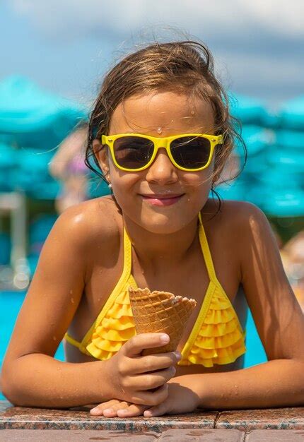 Premium Photo | The child is eating ice cream near the pool. selective focus. kid.