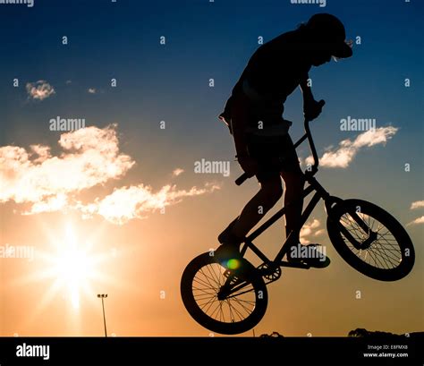 Silhouette of boy doing stunts on his bmx bike Stock Photo - Alamy