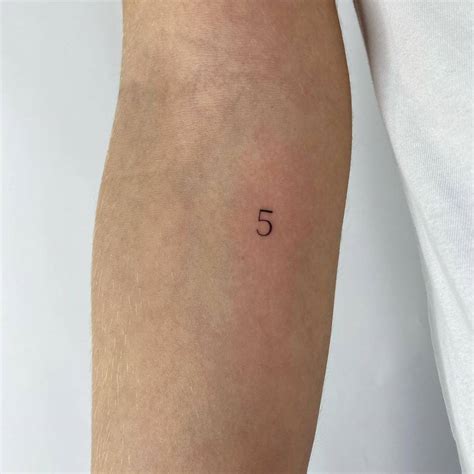 Number 5 tattooed on the inner forearm.