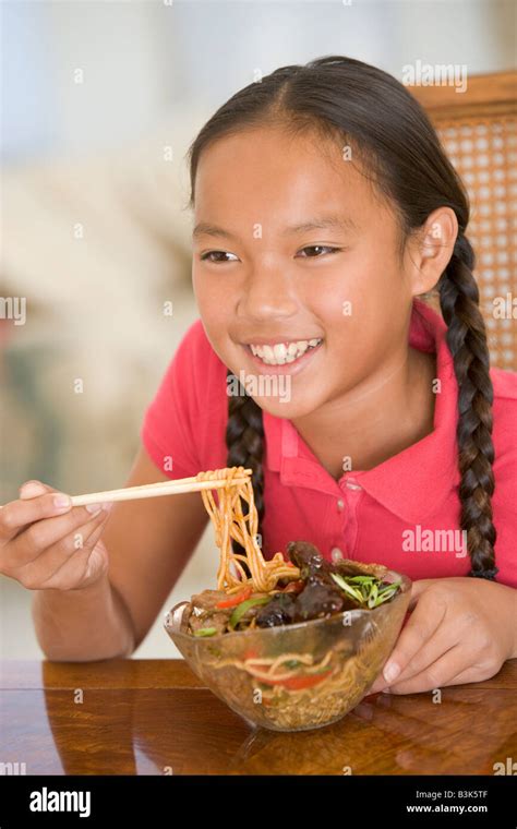 Young girl in dining room eating chinese food smiling Stock Photo - Alamy