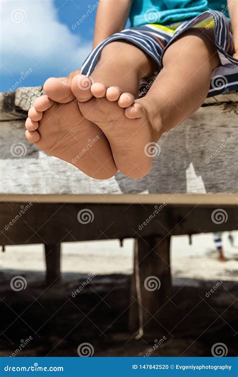 Closeup of Barefoot of a Little Boy Sitting on the Beach, Summer ...