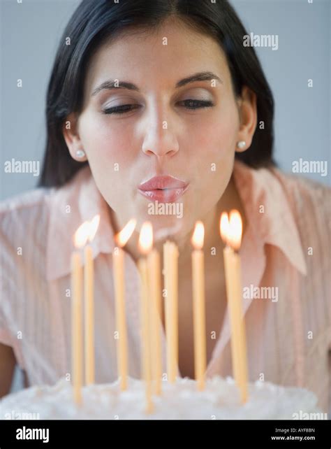 Woman blowing out birthday candles Stock Photo - Alamy