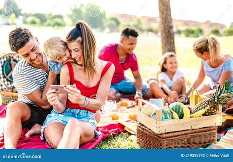 Happy Multiethnic Families Playing with Phone at Pic Nic Garden Party ...