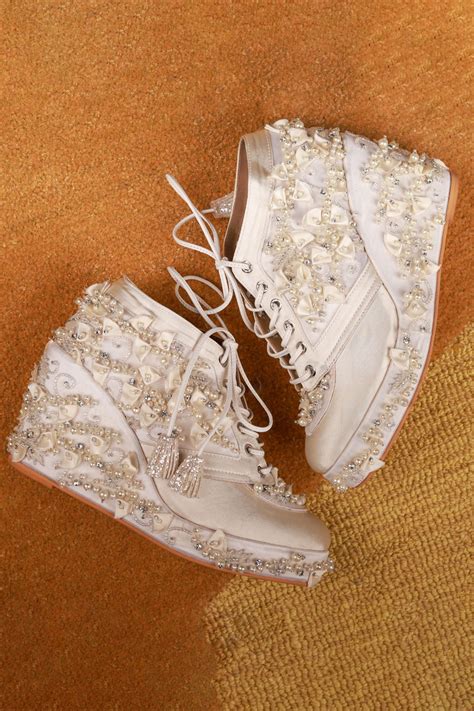 Buy Ivory Embellished Cinderella Sneaker Wedges by Tiesta Online at Aza Fashions.