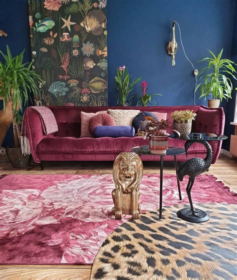 a living room with blue walls and pink couches, rugs and plants on the wall