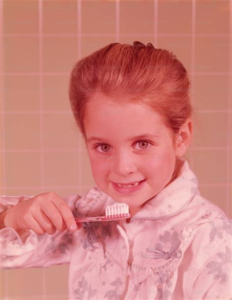 Foto ESTADOS UNIDOS - ALREDEDOR DE 1960: Chica, vistiendo albornoz, cepillándose los dientes en ...