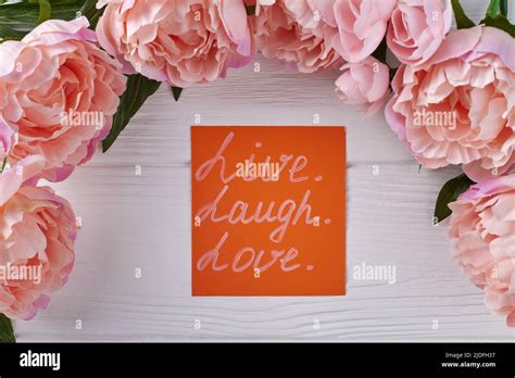 Peony flower frame and orange paper on white desk. Live laugh and love concept Stock Photo - Alamy