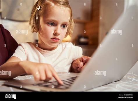 Focused child pressing one button on laptop keyboard Stock Photo - Alamy