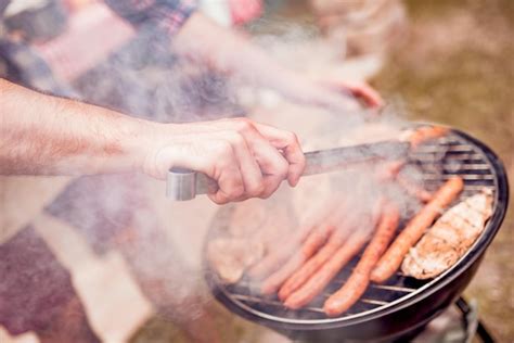 Premium Photo | Handsome happy male preparing barbecue outdoors