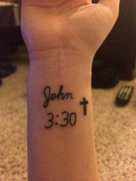 a person with a wrist tattoo that says john 3 30 and has a cross on it