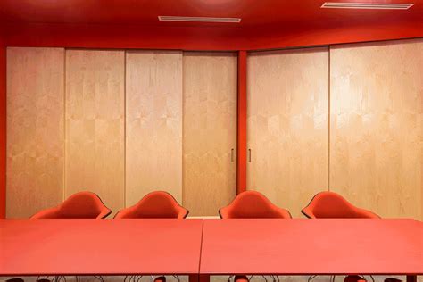 an empty conference room with red chairs and wooden partitions