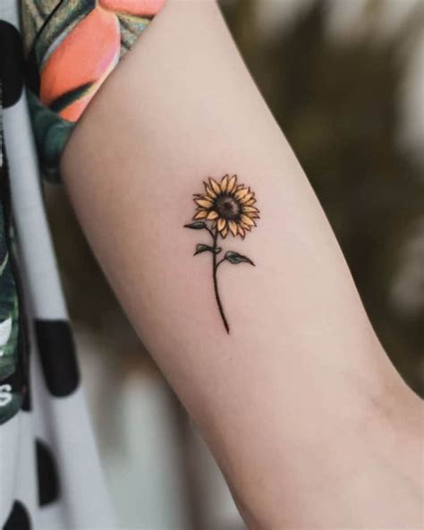 a small sunflower tattoo on the arm