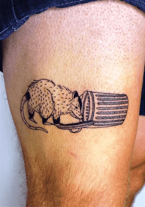 a man's thigh with a tattoo of a mouse in a barrel on it