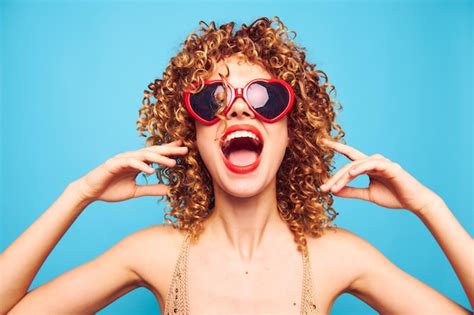 Premium Photo | Cheerful woman red lips hands near face open mouth curly hair