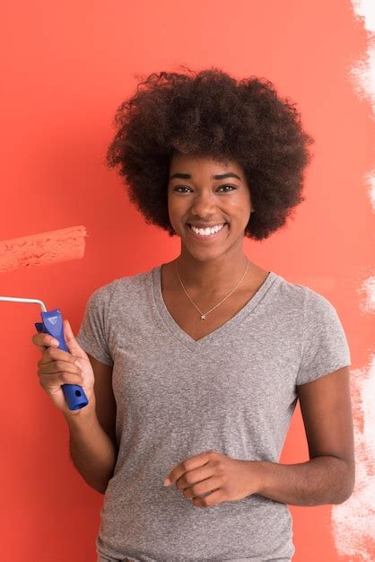 Premium Photo | Portrait of a young beautiful african american woman painting wall in her new ...