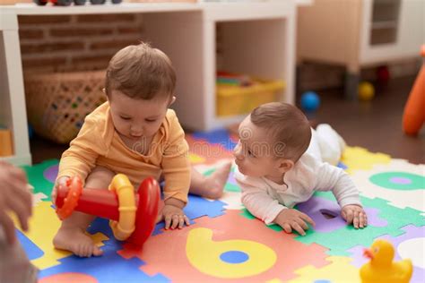 Two Toddlers Playing with Toys Sitting on Floor at Kindergarten Stock ...