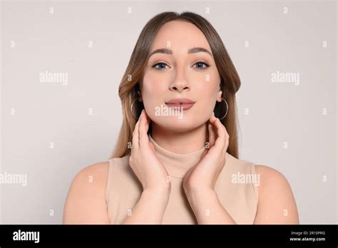 Young woman with lip piercing on white background Stock Photo - Alamy