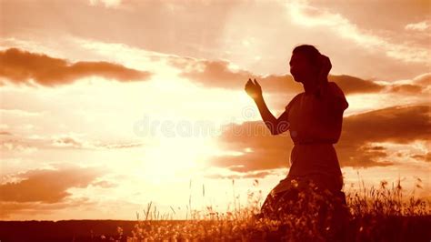 Girl Folded Her Hands in Prayer Silhouette at Sunset. Woman Praying on Her Knees. Slow Motion ...