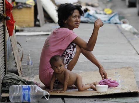 Homeless mother, with one of her children in Manila, Philippines. This ...