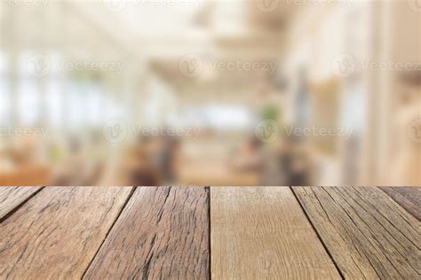 Empty wooden table top perspective with blur coffee shop background, used for montage or display ...