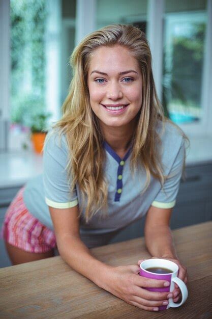 Premium Photo | Pretty young woman leaning on table while having coffee