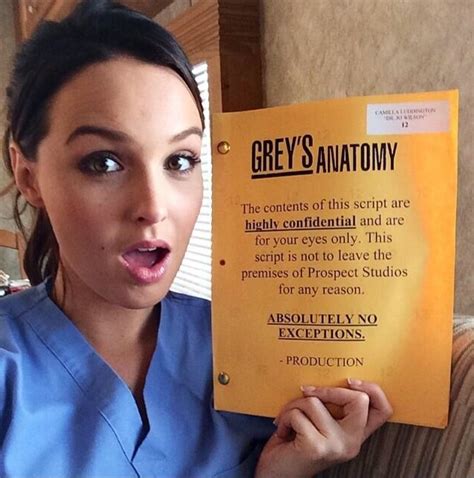 a woman in scrubs holding up a sign that reads grey's anatomy the contents of this script are ...