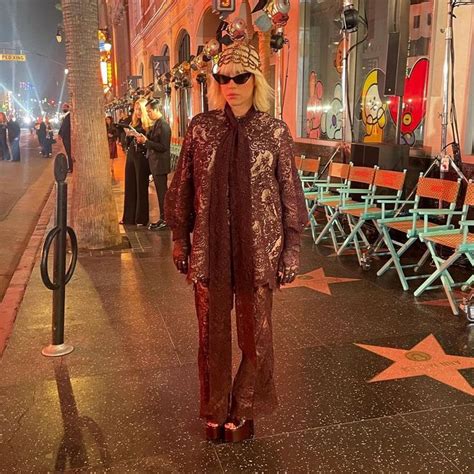 a woman is standing on the hollywood walk of fame with her hat and ...