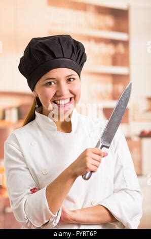 Woman chef wearing cooking outfit posing happily holding up cheese ...
