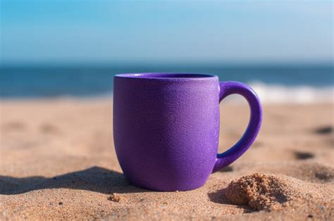 Purple Mug Mockup in the Sand Sea Graphic by imagify design · Creative Fabrica